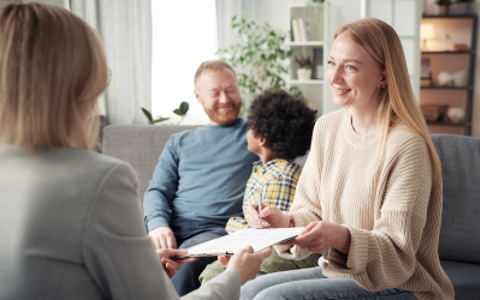 Foster carers with foster child talking to social worker