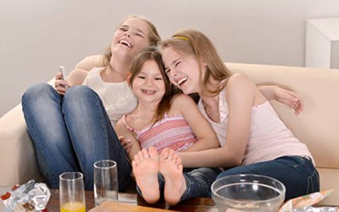 Ellie, Holly and Cleo sat on sofa laughing